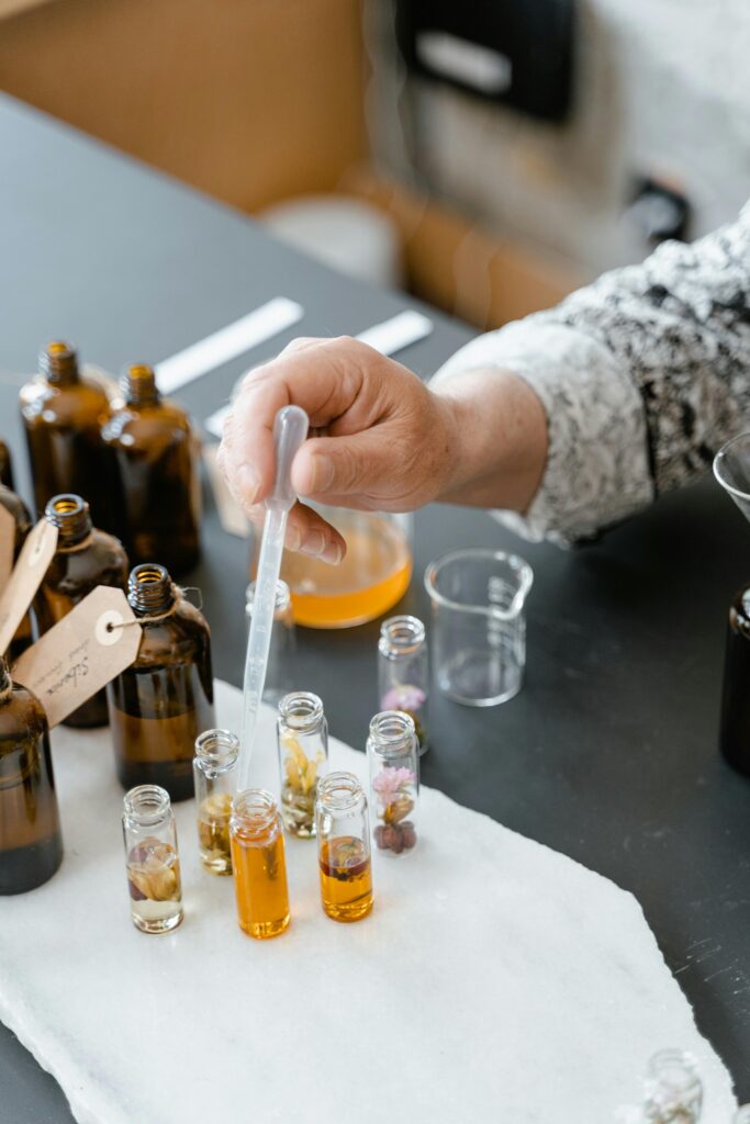 A person blending various natural essential oils in small bottles for aromatherapy.